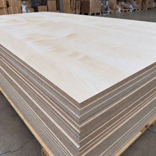 BB/BB Baltic Birch Plywood 3/4 inch 4x8 sheets stacked in a warehouse, showing natural birch wood grain, exposed multi-ply edges, and layered construction.