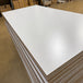Close-up of light gray prefinished plywood with a multi-ply poplar core.