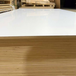 Stack of Prefinished White Melamine Plywood 4x8 sheets with glossy white surface and uniform layered birch core